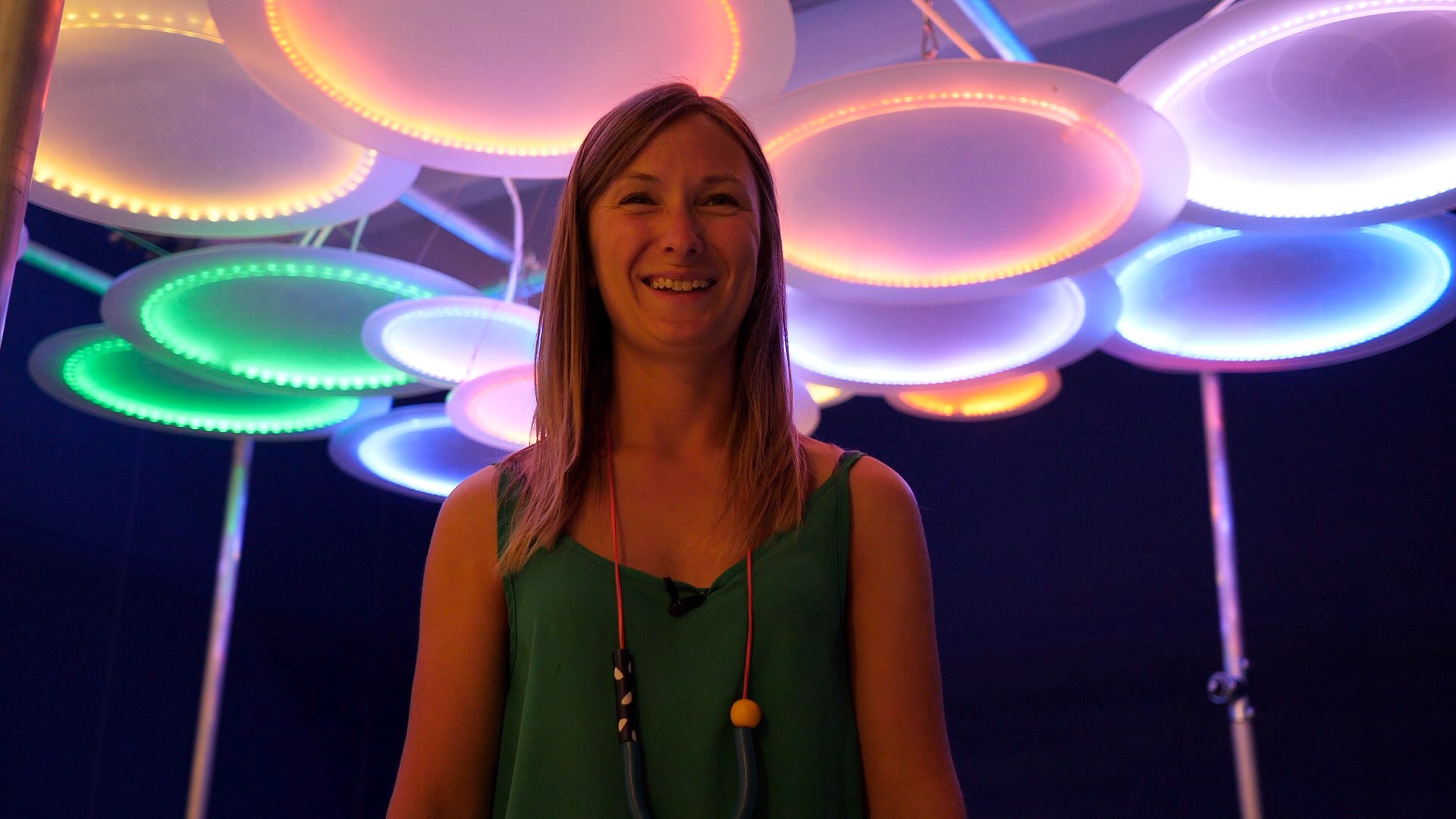 Artist Julia Snowdin surrounded by neon lights.