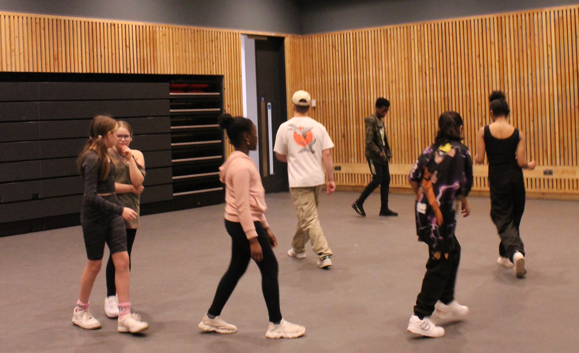 Dancer Tom Hughes Lloyd leading a group of young people in a movement activity.
